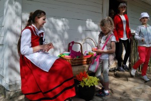 Majówka 2019, dzień pierwszy, skansen w Sierpcu - przed wiejską chałupą, dzieci uczą się robić kwiaty z bibuły