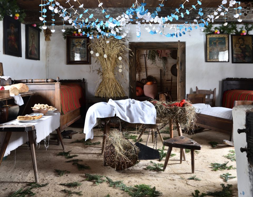dekoracje wigilijne w wiejskiej izbie, na ławie sianko i biały obrus, na polepie igliwie, pająk promienisty na suficie