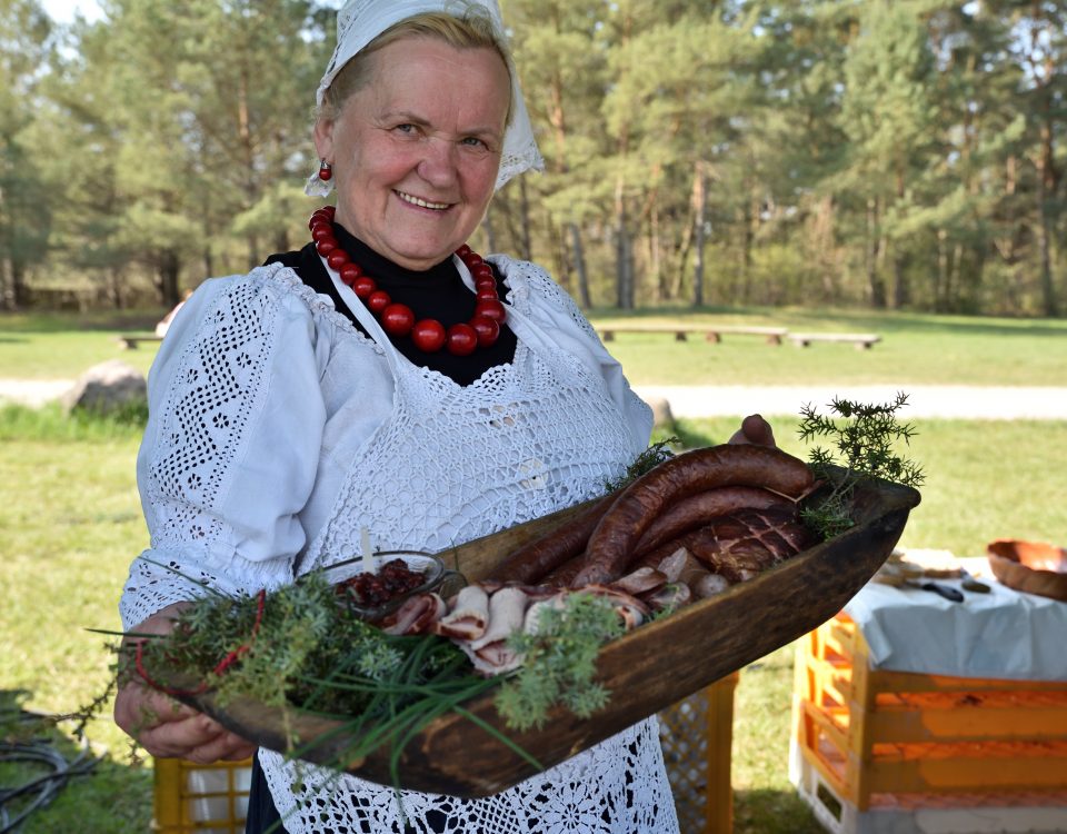 Jedna z uczestniczek konkursu kulinarnego trzymając a w dłoniach przyrządzone przez siebie danie
