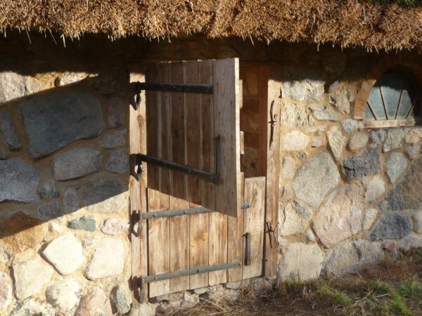 Drewniane drzwi przedzielone poziomo w połowie - dolna połowa zamknięta, górna otwarta